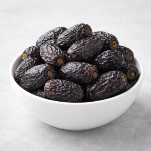 Close-up of premium black Ajwa dates from Madinah showing natural white lines and soft texture, available on MyBarakah.
